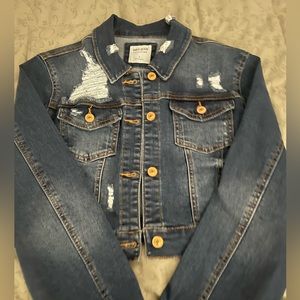Cropped distressed jean jacket. Medium wash